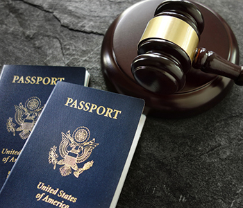 US passports and a judge's gavel on a dark textured surface
